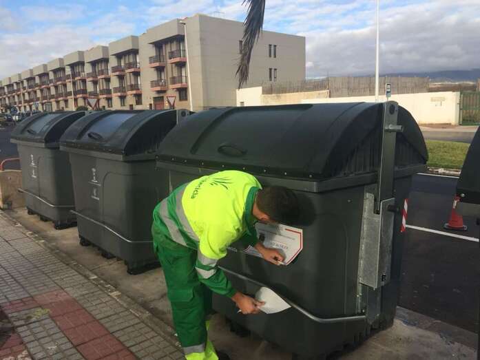 Operario colocando una pegatina en un contenedor (Foto TA)